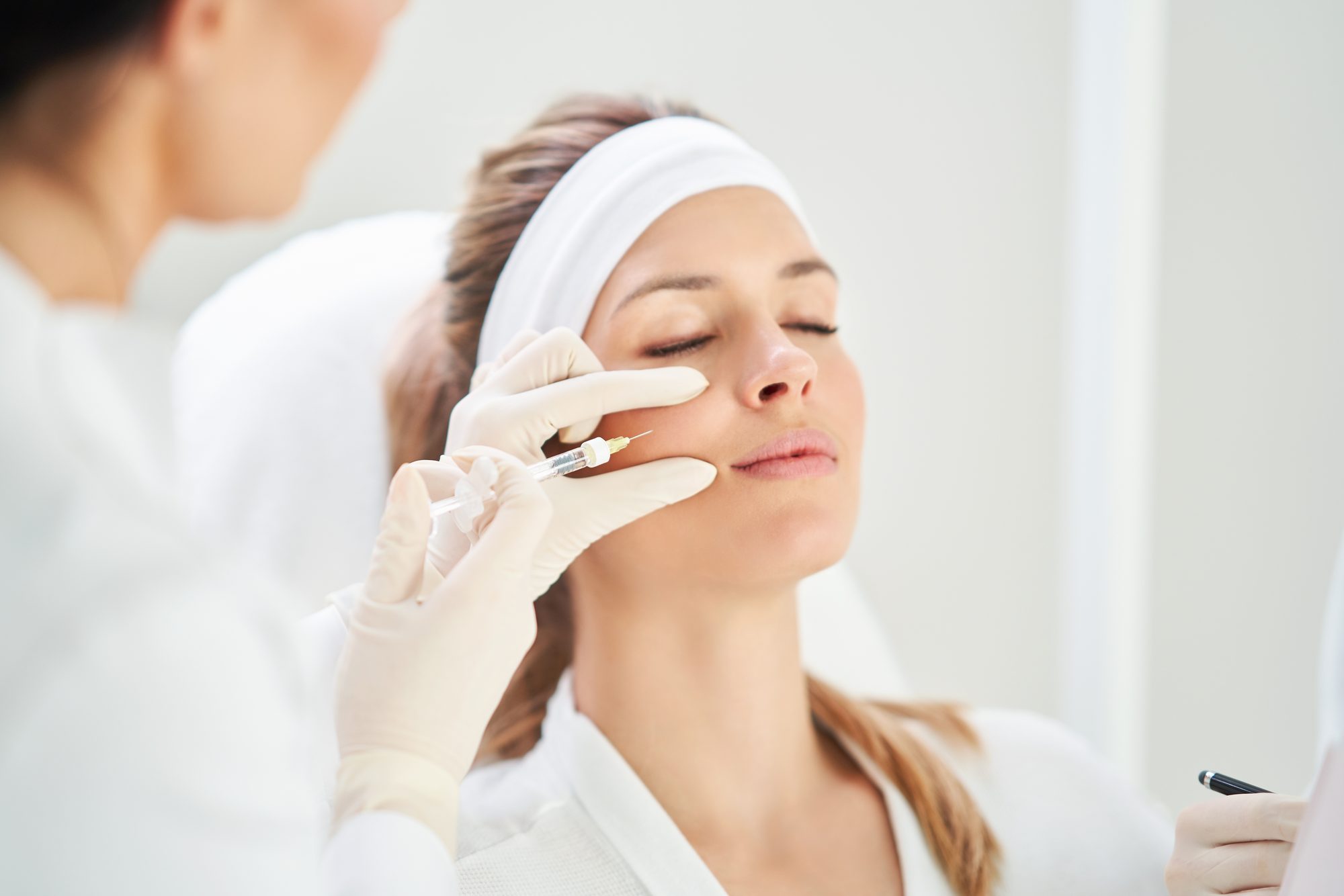Provider administering a neurotoxin injection to a patient’s cheek at Form & Function