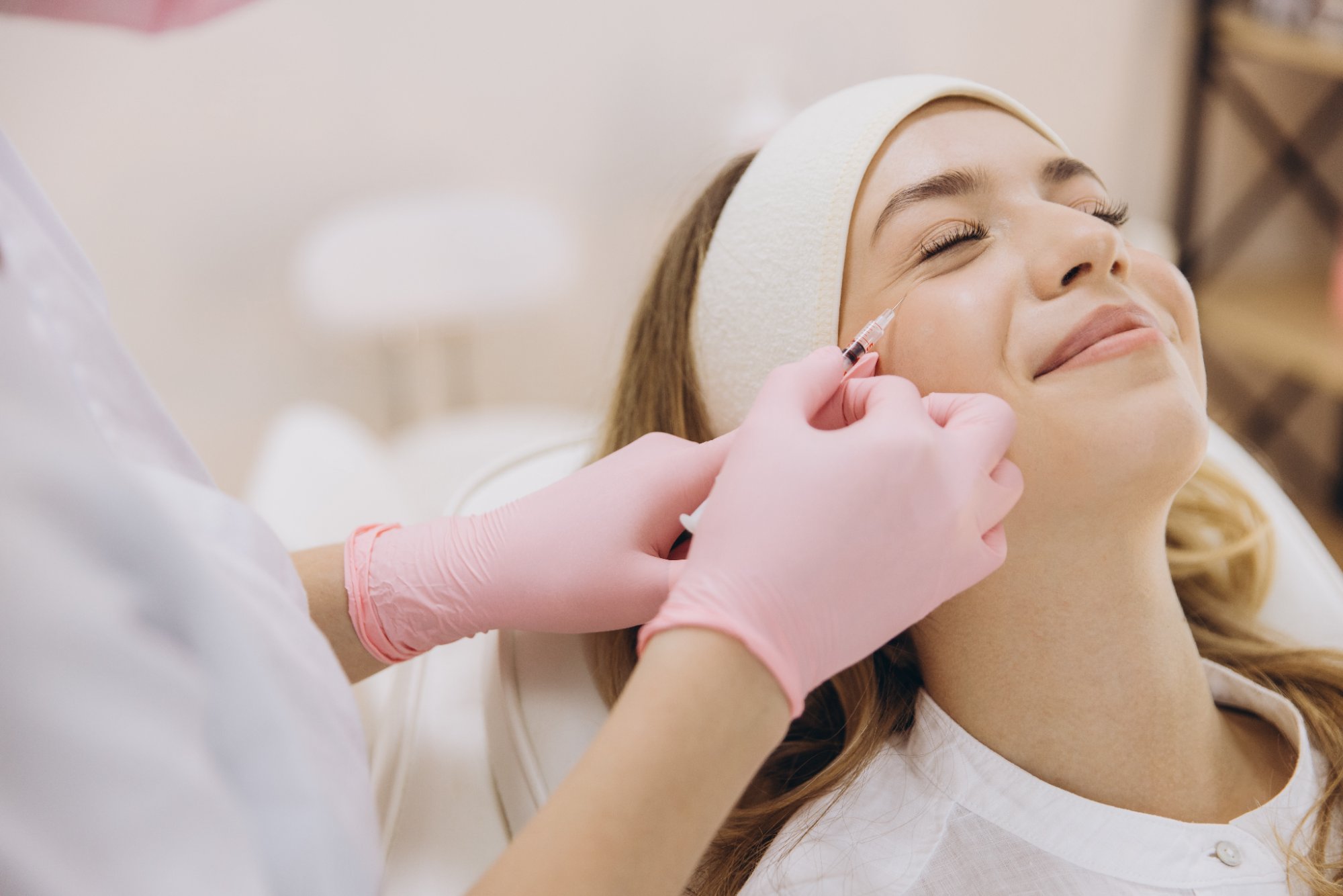 Provider administering an aesthetic injectable to a smiling patient's cheek at Form & Function in Katonah, NY