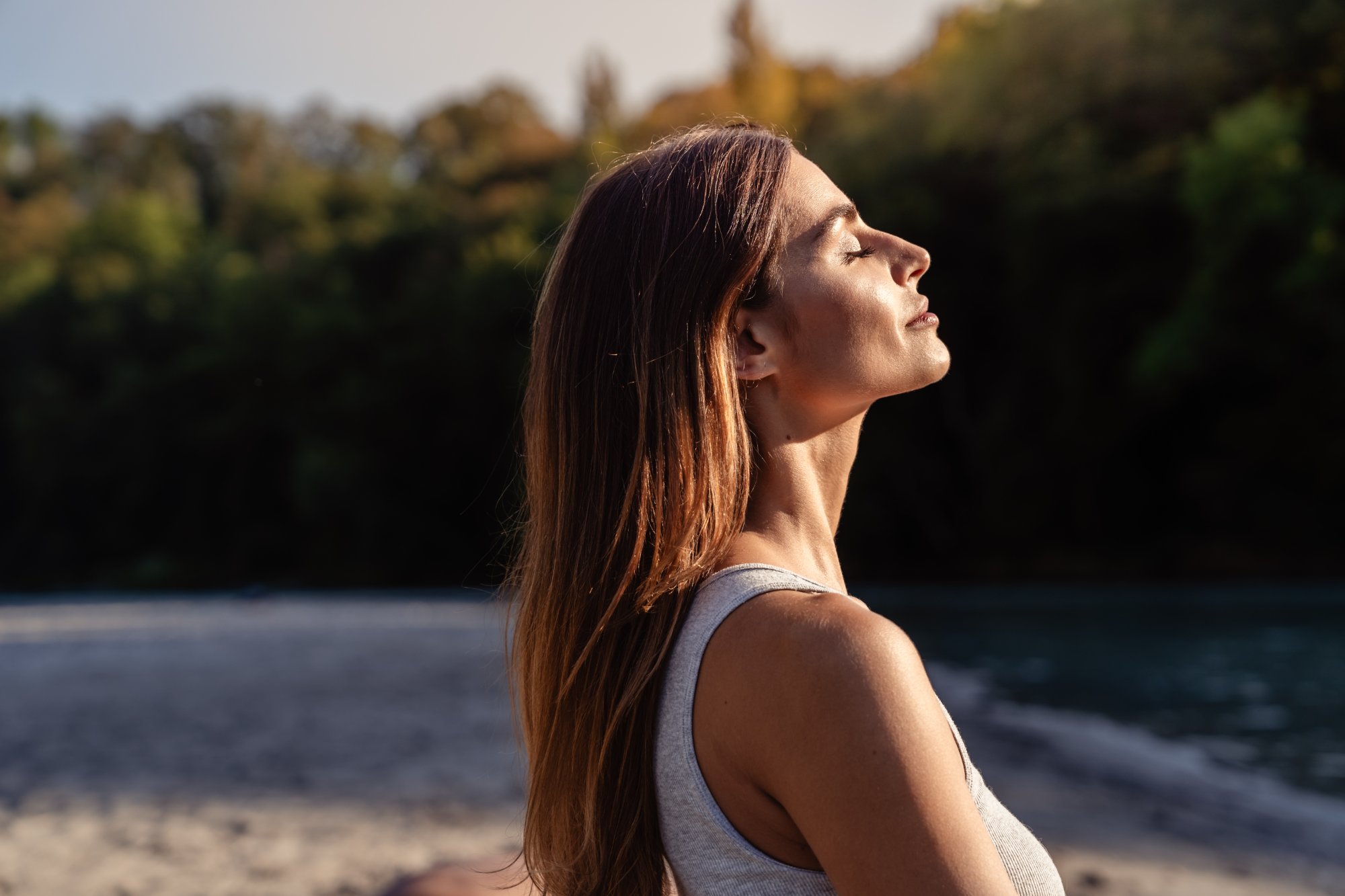 Woman with eyes closed enjoying sunlight outdoors, representing renewed energy after a metabolic reset at Form & Function in Katonah, NY